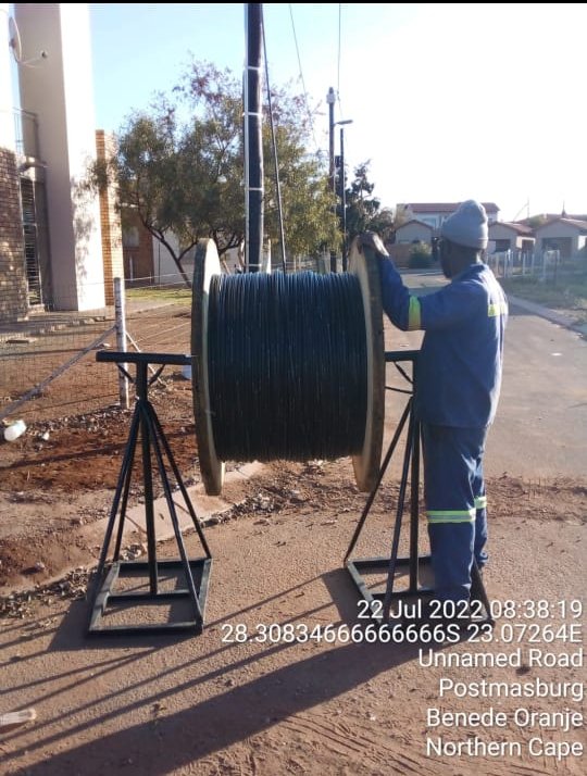 Technician handling a fibre optic cable drum on site